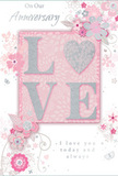 A romantic anniversary card fills the frame, its design a gentle blend of pastel pinks, soft greys, and luminous silver that brings to mind the calm of an early evening stroll through Harringay. At the centre, the word LOVE stands prominently in raised, softly glittered lettering. Each letter is outlined with a delicate shimmer, and the O is imaginatively replaced by a textured silver heart, giving the card a tactile centrepiece that seems made to be traced by hand. The glitter appears finely milled and carefully applied so that it catches the light without overwhelming the design, hinting at the subtle sparkle of dew on petals in a local Harringay garden. Around this central word, an arrangement of illustrated flowers blooms outward in a loose wreath. The blossoms are painted in blush, rose, and gentle mauve tones, their petals feathered at the edges to resemble watercolour brushstrokes. Slender stems curl into graceful swirls, and scattered among them are tiny flourishes: miniature petals, looping tendrils, and a few almost-hidden butterflies that add a sense of movement, as though the whole design were lightly stirred by a breeze off Finsbury Park. The backdrop remains a pale pink wash that fades softly near the card's borders, enhancing the impression of warmth and intimacy. In elegant, flowing script, the phrases On Our Anniversary and I love you today and always appear, placed thoughtfully so as not to crowd the floral artwork. The resulting card feels like a keepsake picked with care from a local Harringay florist, the paper equivalent of a tender, pastel bouquet marking years of shared memories and quiet devotion.